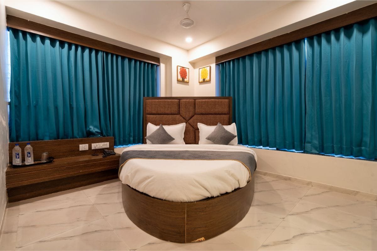 Guest room with a round bed and teal curtains