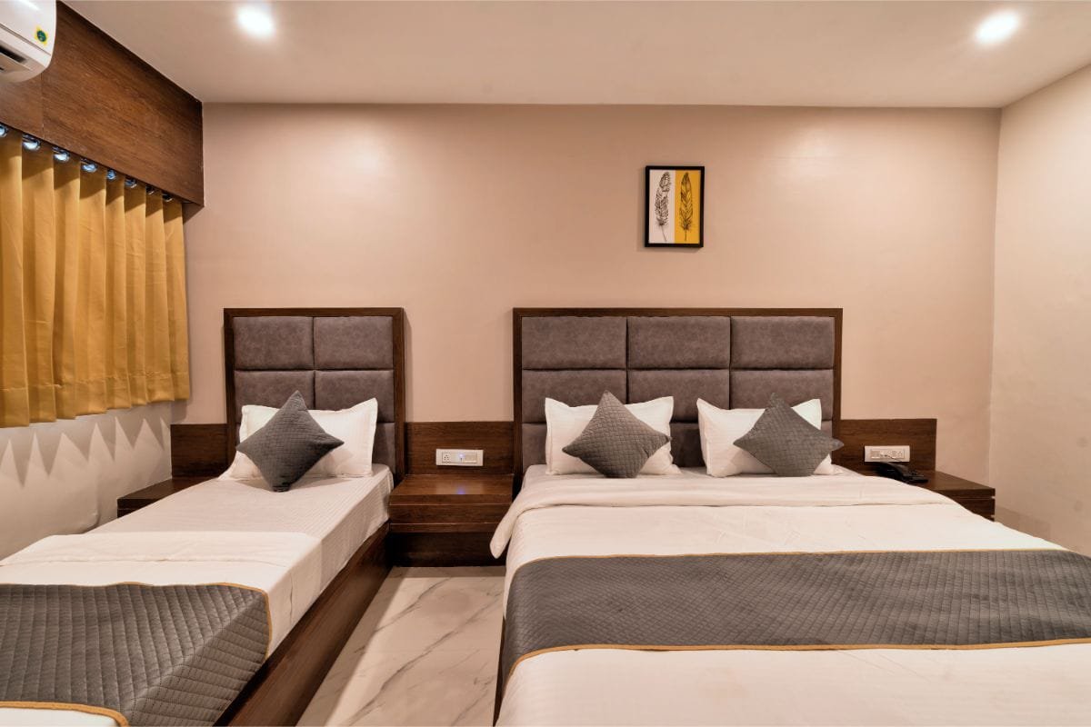 Triple Room at Hotel Royal 24 with three beds and warm lighting