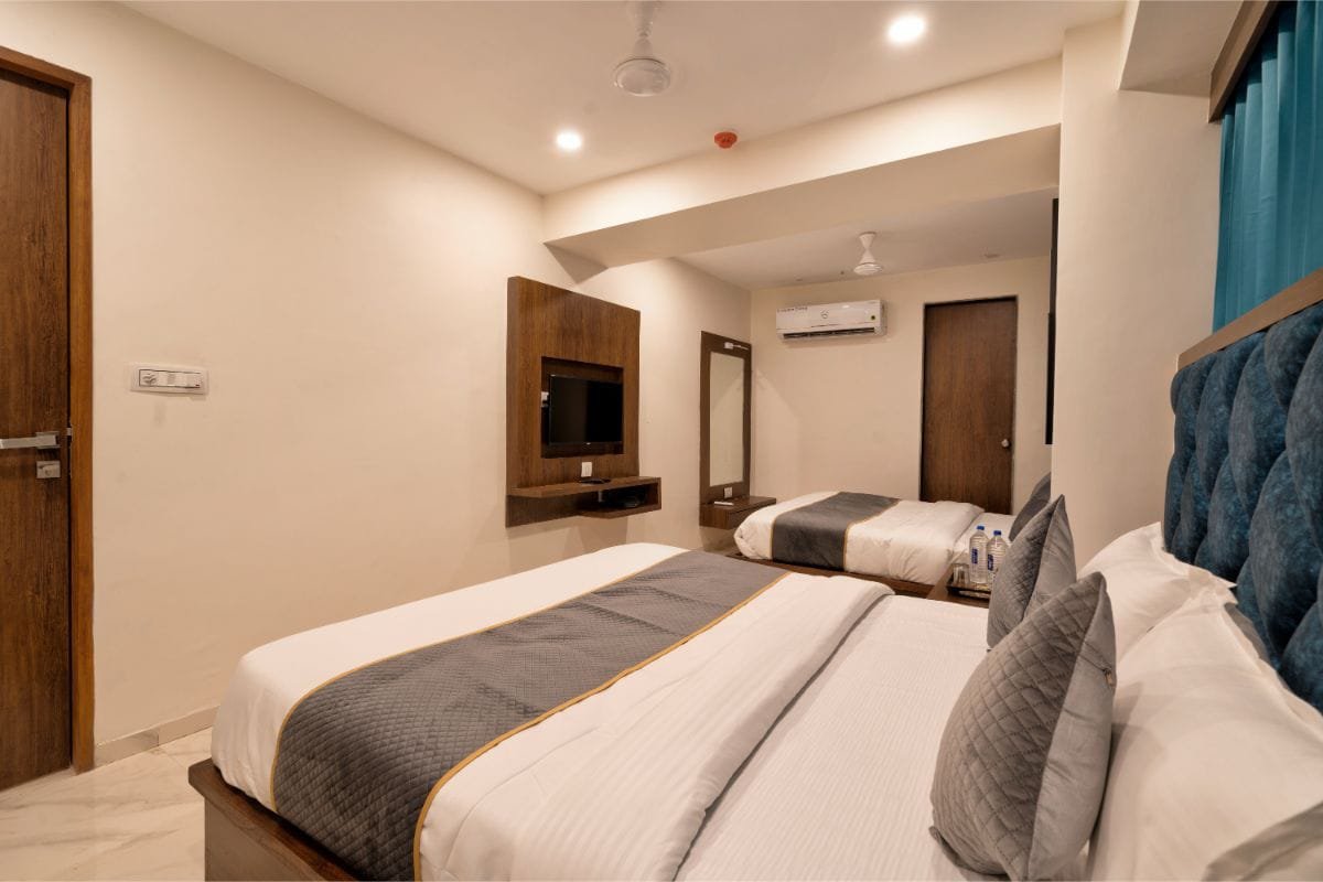 Triple Room with two beds, a television unit and a window